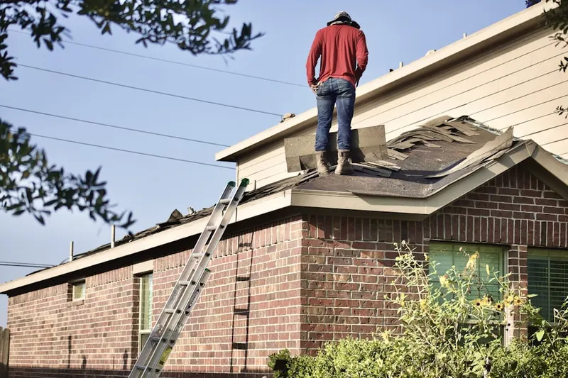 Professional roofer working on a residential roof in Gladwyne